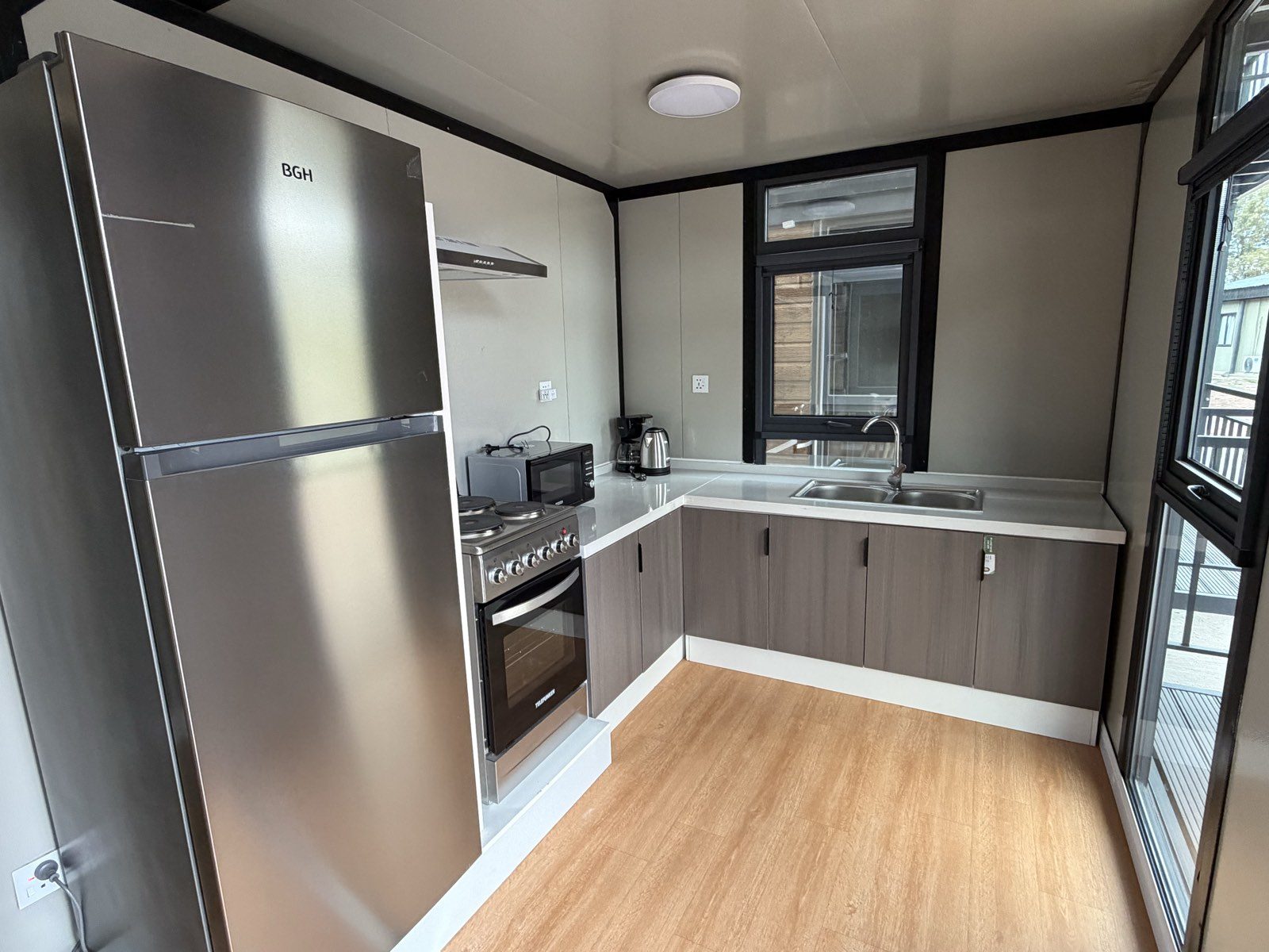 Cocina-comedor integrada del departamento, con heladera, cocina con horno y mesada