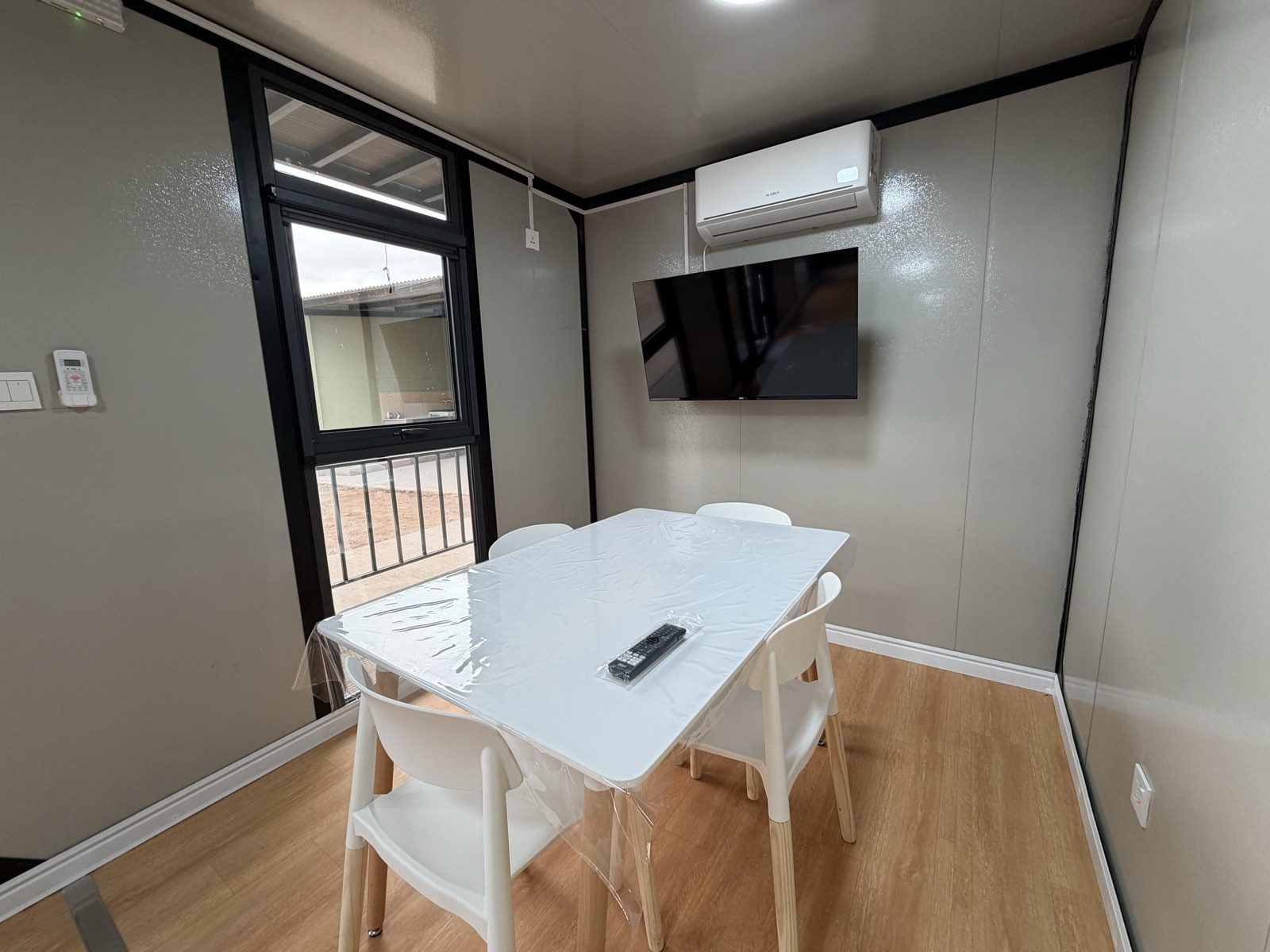 Comedor del departamento, con mesa, sillas, televisor y aire acondicionado