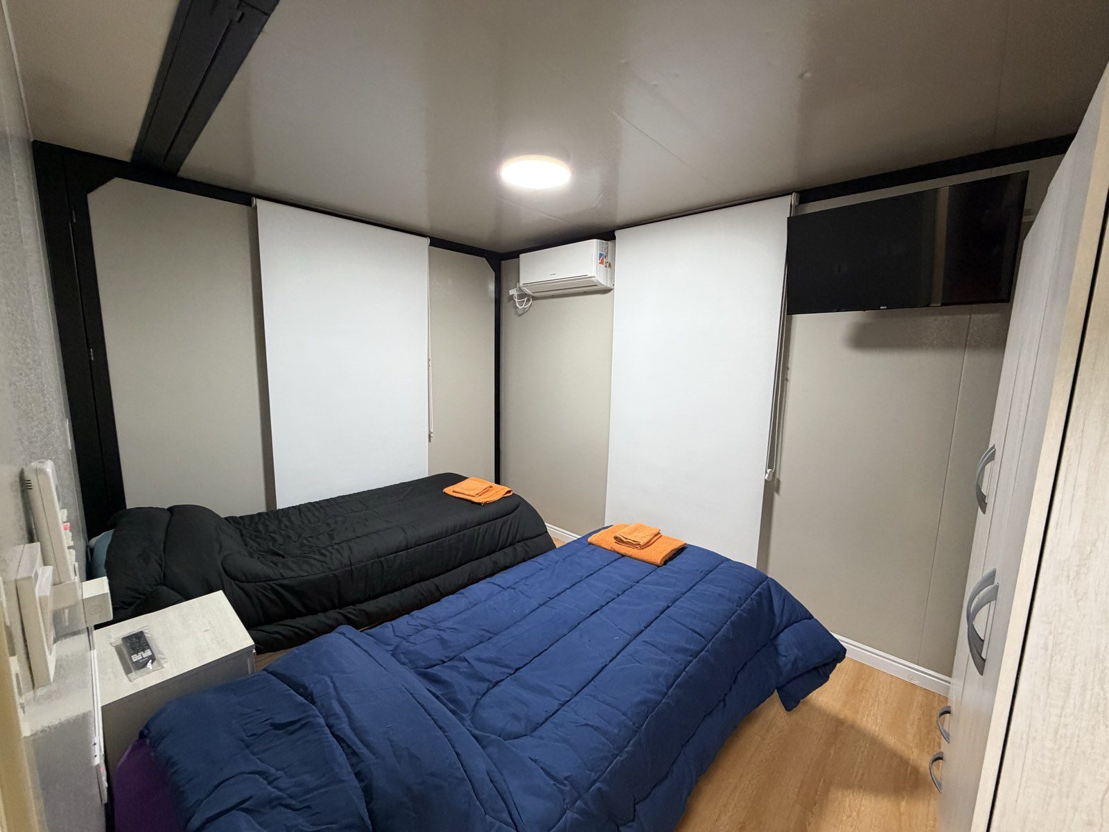 Habitación del departamento con dos camas individuales y aire acondicionado