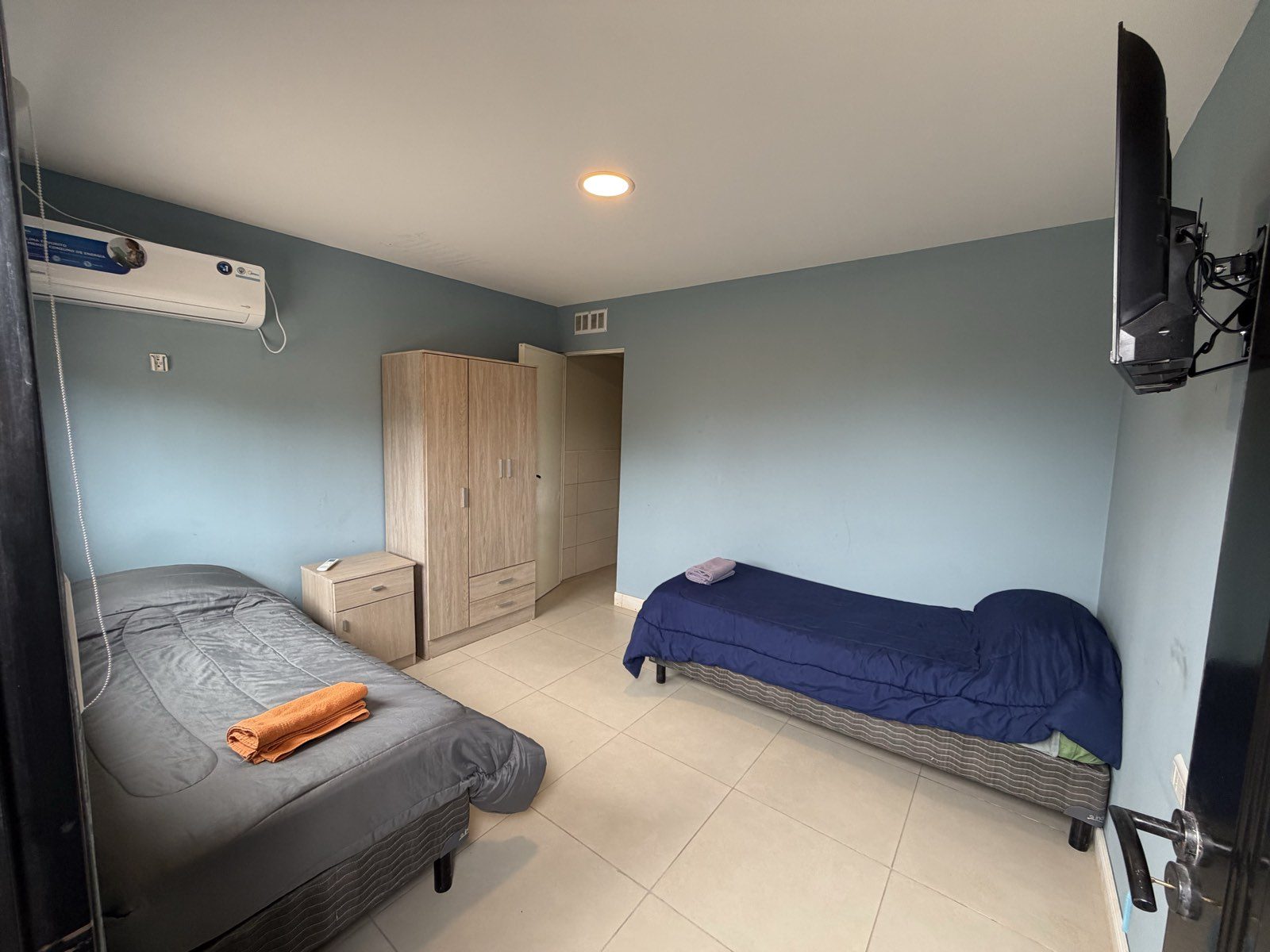 Habitación doble con dos camas individuales, placard, televisor y aire acondicionado